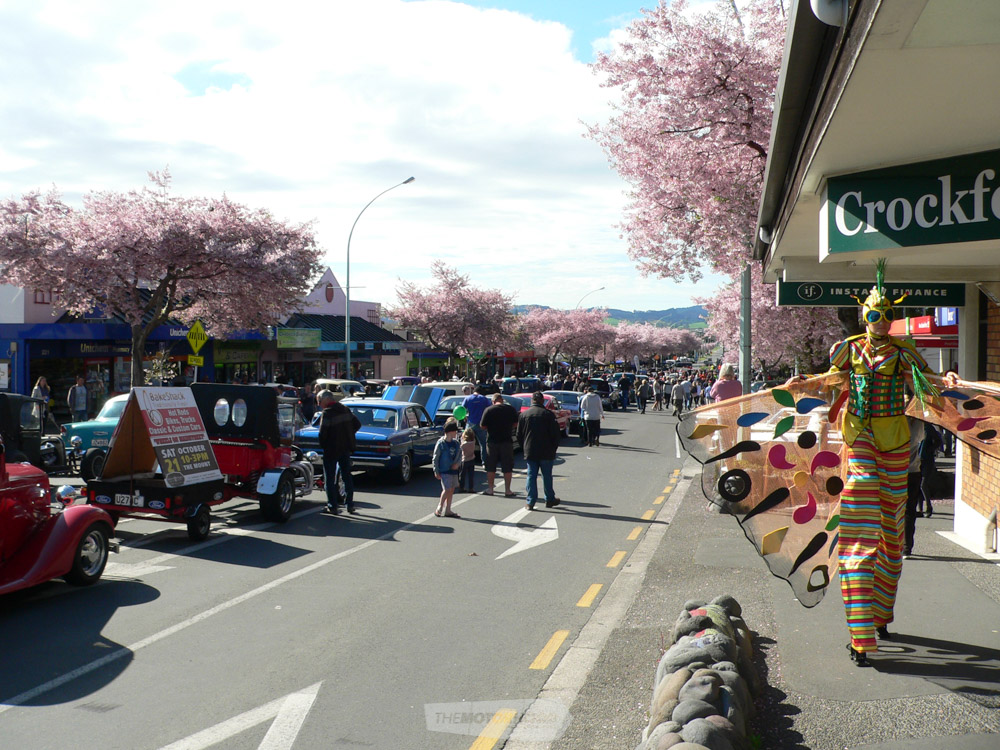 Chadwick Road, cars on display, Cherry Blossoms and the stilt walker dressed up as a giant moth.jpg